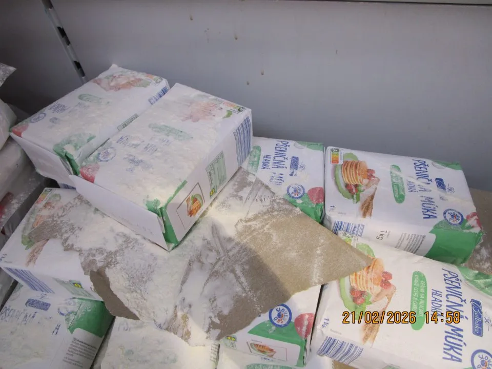 Regál s múkou v predajni znečistený rozsypanou múkou, predaj múky v poškodených obaloch