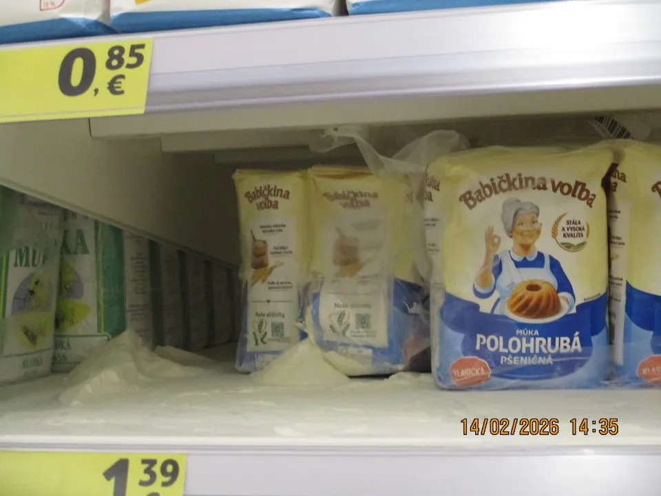 Regál s múkou v predajni znečistený rozsypanou múkou, predaj múky v poškodených obaloch