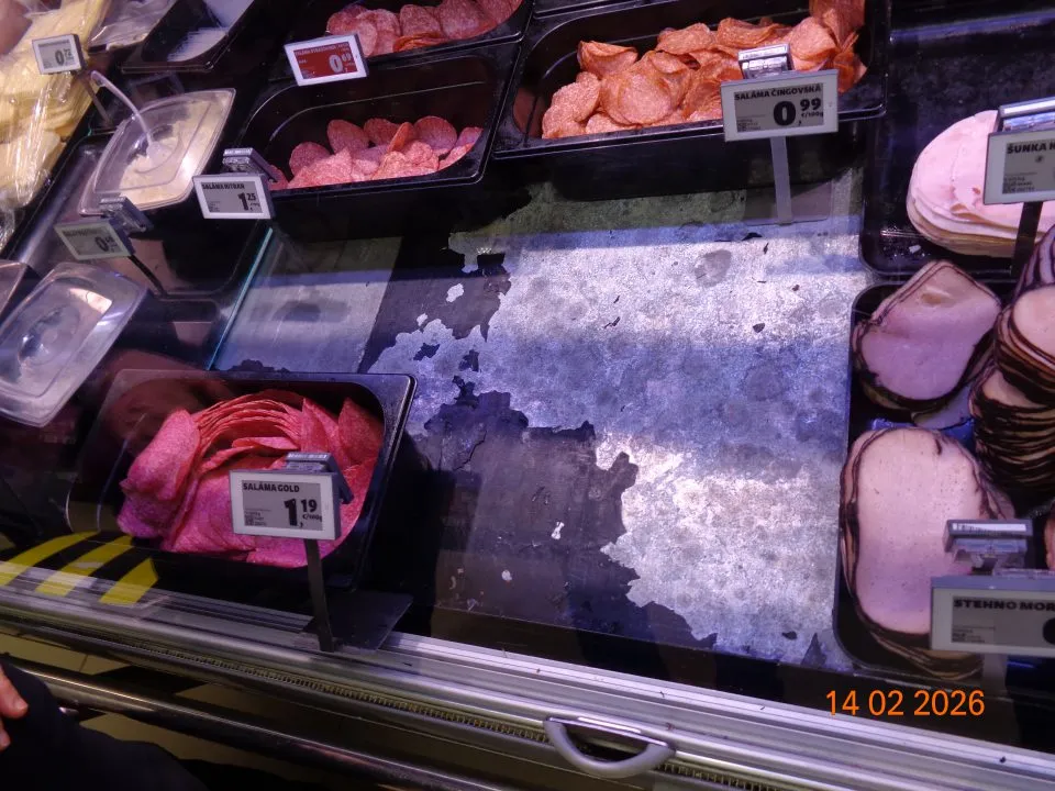 Na predajnej ploche v chladiacej vitríne s mäsovými výrobkami olupujúci sa náter